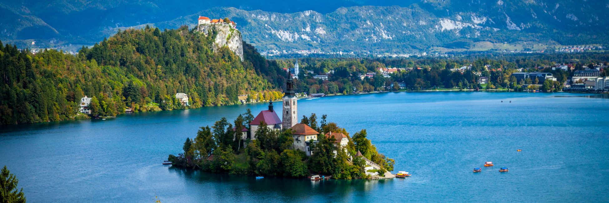 The vibrant blue lake surrounds a small island in Slovenia